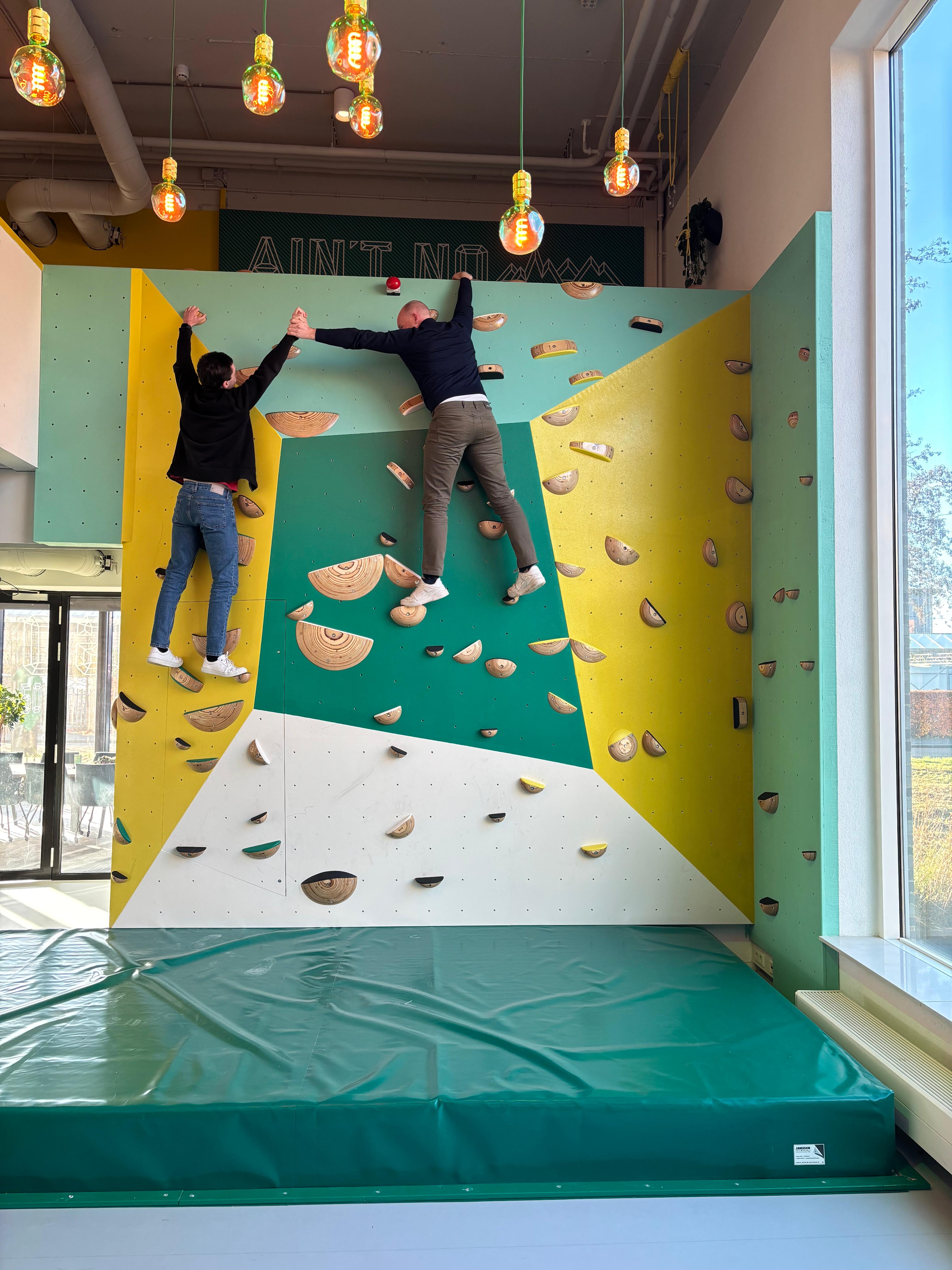 Kobeon teamleden klimmen op indoor klimwand